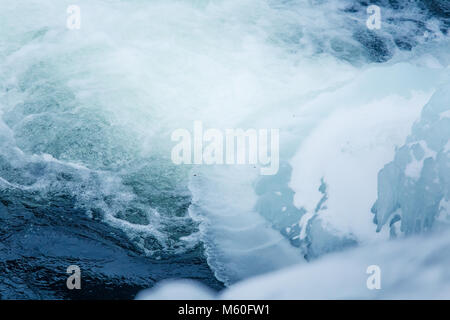 Beautiful frozen waterfall in central Norway. Winter landscape with a frozen river and ice formations. Stock Photo