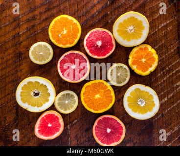 Sliced lemon, orange and pink grapefruit on wooden table Stock Photo