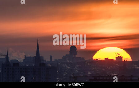 27 February 2018, Germany, Berlin: The sun rises in the capital. The silhouette of the radar tower (C) can be seen. Photo: Paul Zinken/dpa Stock Photo