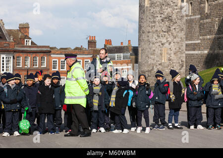 Windsor, UK. 27th February, 2018. A ceremonial warden informs children about the Changing of the Guard ceremony at Windsor Castle. Credit: Mark Kerrison/Alamy Live News Stock Photo