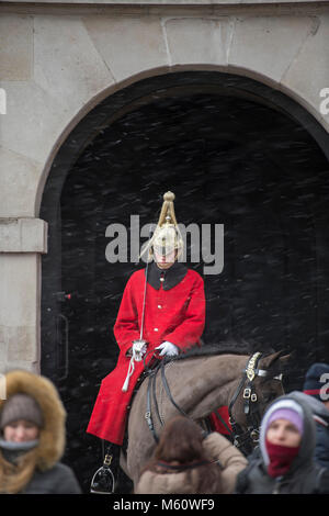 Whitehall, London, UK. 27th Feb, 2018. A mounted Life Guard on sentry duty at the entrance to Horse Guards as snow begins to fall in central London. Credit: Malcolm Park/Alamy Live News. Stock Photo