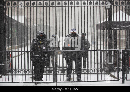 London, UK. 27th February, 2018. Beast from the East storm hits London. 27th February 2018. Heavy snow showers hit Whitehall London today. Armed Police outside Downing Street gates cover up fromn the snow as ‘Beast from the East’ reaches London. Credit: Clickpics/Alamy Live News Stock Photo
