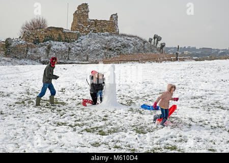 Hastings, winter, East Sussex, UK, 27 Feb 2018. A family have fun building a snowman by Hastings Castle, in the snowy landscape at Ladies Parlour. Stock Photo