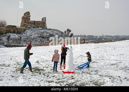 Hastings, winter, East Sussex, UK, 27 Feb 2018. A family have fun building a snowman by Hastings Castle, in the snowy landscape at Ladies Parlour. Stock Photo