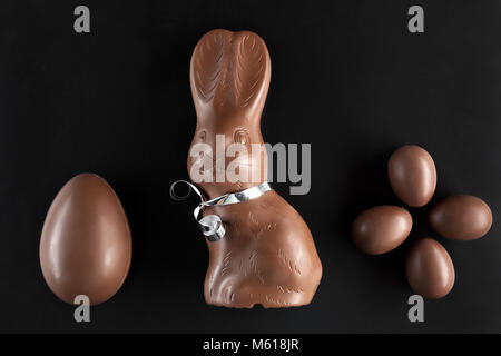 Delicious chocolate Easter bunny and eggs on dark background Stock Photo