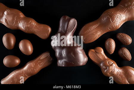 Delicious chocolate Easter bunny and eggs on dark background Stock Photo