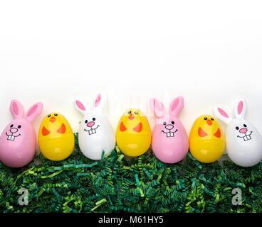 Plastic bunny and chick eggs on green grass Stock Photo