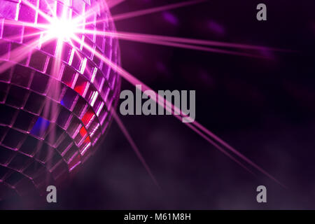 Retro disco ball with violet star burst reflections and fog in club Stock Photo