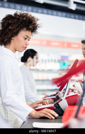 Cheerful pharmacist holding two packs of medicine and giving advices Stock Photo