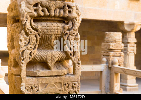 Beautifully carved ancient sandstone pillar with more pillars in the background. The amazing carving inside the Jaisalmer fort in Rajasthan make this an amazing tourist destination Stock Photo