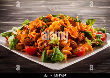 Pasta with tomato sauce on wooden table Stock Photo