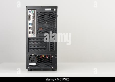 Back side of midi tower computer case on white table Stock Photo