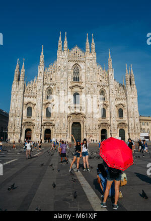 Milan, Italy - June 23rd, 2017: Asian tourists pose for a picture in front of the Milan's iconic Duomo cathedral. Italy remains popular travel destination for Asians Stock Photo