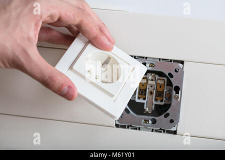 Close-up Of Technician Repairing Metal Electrical Socket Stock Photo