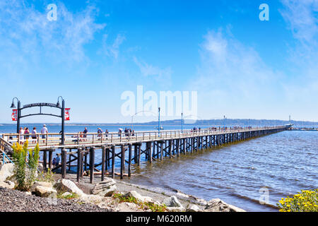 WHITE ROCK, CANADA - JULY 23, 2010: Locals and tourists stroll along the famous 1,500 ft. long pier in White Rock, BC, surrounding Semiahmoo Bay Stock Photo