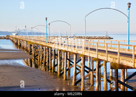 Low tide at the famous 1,500 ft. long wooden pier in White Rock, BC, surrounding Semiahmoo Bay near Vancouver. Stock Photo