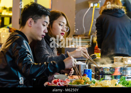A man and woman eat Vietnamese street food, Hanoi, Vietnam. Stock Photo