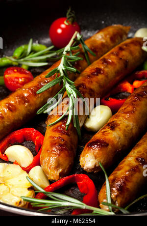Closeup of Wiener Sausages with vegetables in a pan Stock Photo