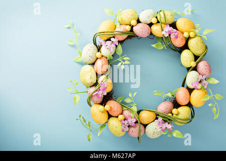 Easter eggs wreath on light blue background Stock Photo
