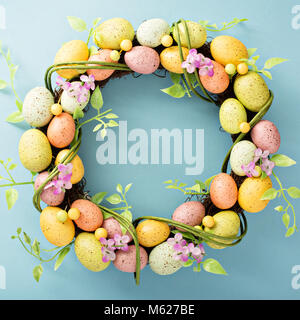 Easter eggs wreath on light blue background Stock Photo