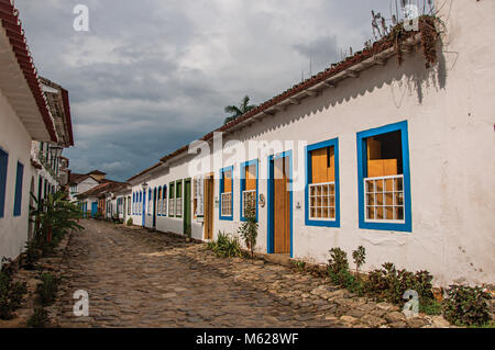 View of shops in old houses and cobblestone on cloudy day in Paraty, an amazing and historic town in the Rio de Janeiro State coast, Brazil. Stock Photo