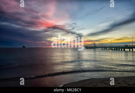 Dramatic fiery sunrise by the jetty at Palm Cove Beach, Cairns Northern Beaches, Far North Queensland, FNQ, QLD, Australia Stock Photo