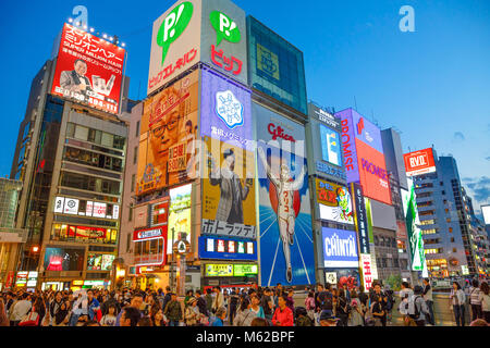 Osaka, Japan - April 29, 2017: crowd of people during the Golden Week in the streets of Dotonbori area illuminated by bright neon lights in Namba Osaka, a popular nightlife and entertainment district. Stock Photo