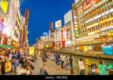 Osaka, Japan - April 29, 2017: tourists walking in night shopping street at Dotonbori Canal in Namba Osaka, a popular nightlife and entertainment district. Blue hour shot. Stock Photo