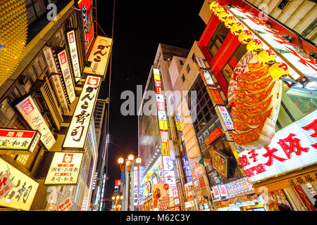 Osaka, Japan - April 29, 2017: prospective view of Namba District by night with various food signages. Namba is also known as an entertainment district with bars, restaurants and trendy shops Stock Photo
