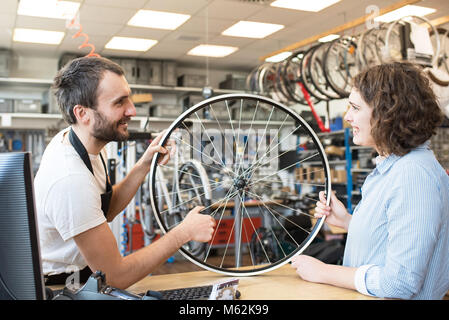 customer and dealer in bicycle shop - purchase and repair of bicycles - customer service Stock Photo