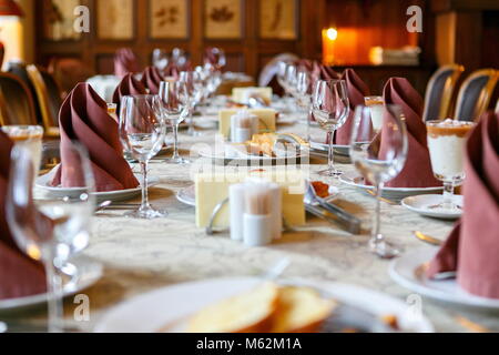 Table setting before the event. Willingness to receive guests. Perspective and lines, neatly before filing. Empty glasses and plates. There are snacks Stock Photo