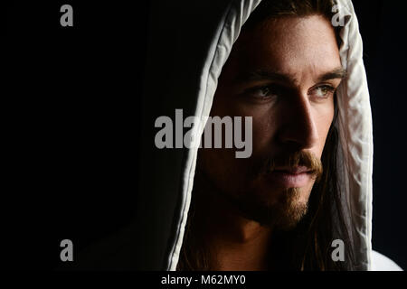 Handsome and mysterious young man wearing a white hoodie Stock Photo