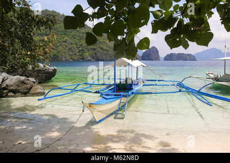 Bangka boat docked on the sand in Bacuit Bay near El Nido, Palawan, Philippines. Paradise, summer vacation destination concept Stock Photo