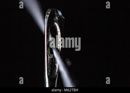 Macro close up thread through of eye of needle in black and white Stock Photo