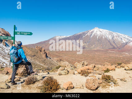Male hiker with fantastic view of snow covered El Teide from Degollada de Guajara in Teide national on Tenerife, Canary Islands, Spain Stock Photo