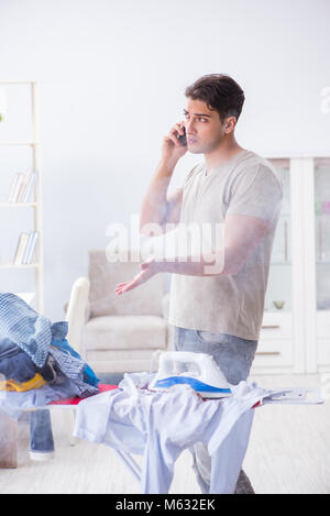 Inattentive husband burning clothing while ironing Stock Photo