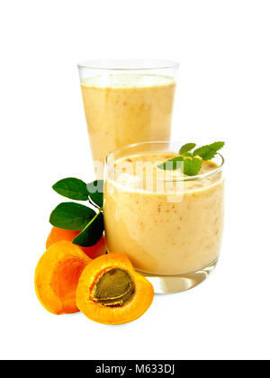 High and low glassful with a milky apricot cocktail, fruit isolated on a white background Stock Photo