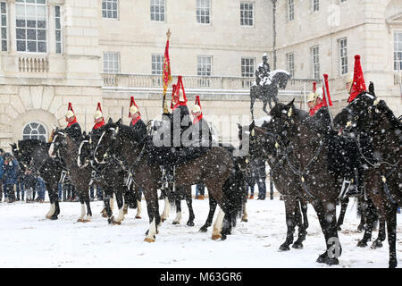 London, UK. 28th Feb, 2018. Members of the Household Cavalry Mounted Regiment wait in the snow at the Changing of the Queen's Life Guards ceremony at Horse Guards Parade during a snow shower in London, England. Credit: Paul Brown/Alamy Live News Stock Photo