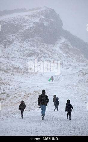 Edinburgh, Scotland, UK. 28th February, 2018. What started as an exciting family winter trip to Holyrood Park to have fun sledging turned into a nightmare with young children howling as they were caught in a blizzard of snow. The radio had just announced that the amber alert for severe weather had just become a red warning Stock Photo