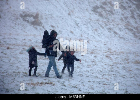 Edinburgh, Scotland, UK. 28th February, 2018. What started as an exciting family winter trip to Holyrood Park to have fun sledging turned into a nightmare with young children howling as they were caught in a blizzard of snow. The radio had just announced that the amber alert for severe weather had just become a red warning Stock Photo