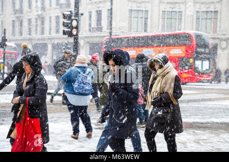 London, UK. 28th Feb, 2018. UK Weather: Heavy snow caused severe early delays for millions of London commuters, people walking around the centre of the capital (Oxford Circus) shielding from wind and snow Credit: Nathaniel Noir/Alamy Live News Stock Photo