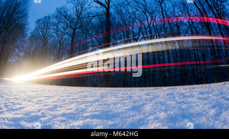 Sehnde, Germany. 28th Feb, 2018. Long exposure shot showing light traces left by cars driving along a surface road through a forest in the Hannover region in Germany, 27 February 2018. Credit: Julian Stratenschulte/dpa/Alamy Live News Stock Photo