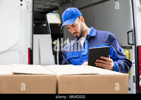 Portrait Of A Happy Young Male Worker Using Tablet Stock Photo