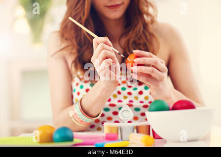 Attractive woman painting Easter eggs at home Stock Photo