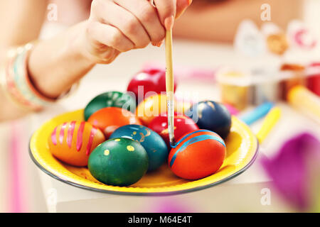 Attractive woman painting Easter eggs at home Stock Photo