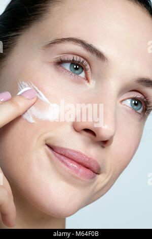 Woman applying face cream Stock Photo