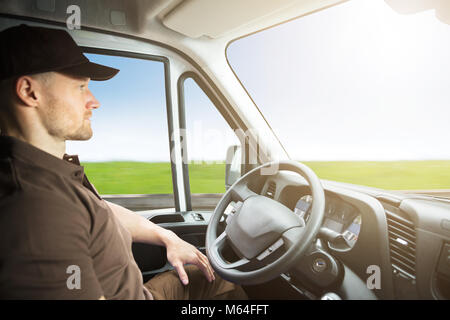 Portrait Of A Young Delivery Man Sitting Inside Self Driving Van Stock Photo