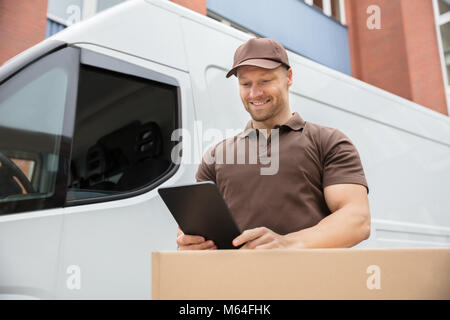 Happy Delivery Man Standing Near Van Using Digital Tablet Stock Photo