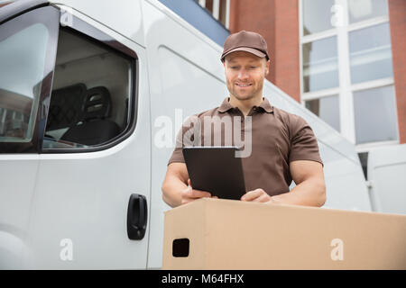 Happy Delivery Man Standing Near Van Using Digital Tablet Stock Photo