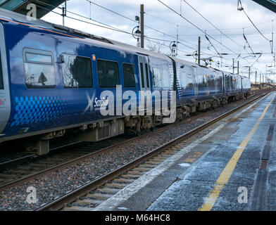 Close up of ScotRail local commuter train at Drem railway station in Winter with salt on station platform, East Lothian, Scotland, UK Stock Photo